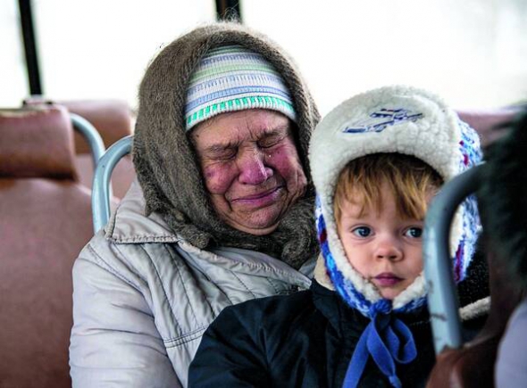 Жінка з Дебальцевого на Донеччині тримає на руках онука, 6 лютого. Тоді в боях довкола міста оголосили тимчасове перемир’я для евакуації жителів. 25 автобусів з городянами виїхали на підконтрольну Україні територію, півавтобуса – до бойовиків
