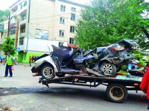 Евакуатор везе автомобіль ”Буд” вулицею Золочева Львівської області. Машина врізалась у стіну поліклініки