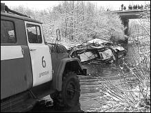 Машина МЧС вытаскивает расплющенный автобус из реки