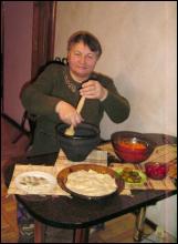 Юлія Пляцушок для куті розтирає мак у макітрі