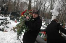 Священники забирают цветы с могилы Кравченко