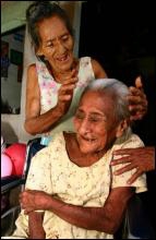 128-летней Крус Эрнандес Ривас делает прическу 80-летняя дочь Патрона