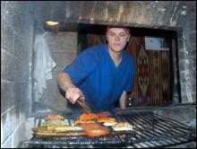 19-летний повар ресторана ”Сова” Роман Ильчук жарит на огне помидоры и баклажаны