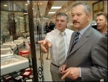 Анатолій Швачка (ліворуч) показує міністру фінансів Вікторові Пинзенику коштовності, які продаватимуть 15 серпня