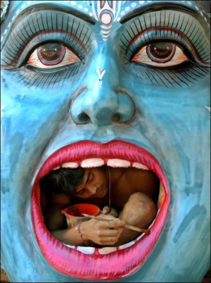 Художник із міста Чандіґарх в Індії розфарбовує ідол індуїстського бога Кришни напередодні Дня незалежності країни