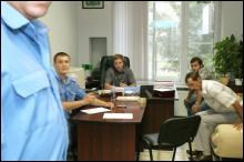Сергей Брыжа (в кресле за столом) в своем кабинете дает показания милиции