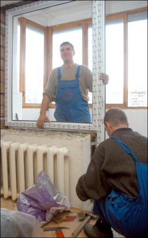 Монтажники окон Василий Прокопенко (на фото слева) и Сергей Долецкий устанавливают балконный блок на Позняках