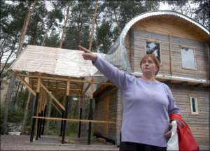 Мешканка Биківні Людмила Жигала біля самовільно зведеної місцевої церкви