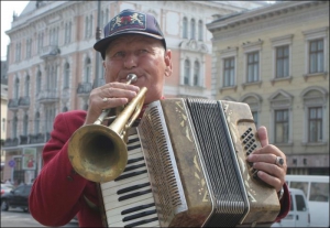 Человек-оркестр Роман Каминский выступает возле гостиницы ”Жорж” во Львове