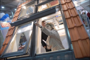 На виставці ”Будівництво та архітектура-2006”, що проходила минулого тижня в ”КиївЕкспоПлаза”, працівник компанії ”Велюкс Україна” Євгенія Запорожець показує мансардні вікна з електричним обладнанням