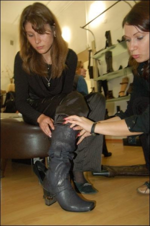 20-летняя киевлянка Елена (слева) в обувном магазине ”Феллини” примеряет сапоги за 1295 гривен. Продавец Леся Онищук (справа) объясняет, что такие модели и называют ”ковбойскими”