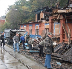 Робітники невідомого підприємства очищують Набережне шоссе від згорілих решток будинку трамвайників 