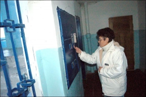 Людмила Онищенко показує зіпсований  електролічильник покійного сусіда. Двері квартири Христенка праворуч 