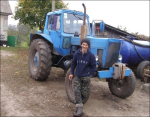 Владимир Малаш во дворе в селе Немовичи Сарненского района Ровенской области показывает сложенный своими руками трактор МТЗ