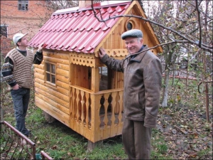 Михайло Татарин (праворуч) із села Слобідка Косівського району Тернопільщини показує дерев’яну хатку, яку зробив на продаж