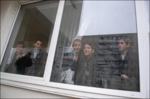 Ученики киевской школы №226 на Оболони во время перерыва выглядывают из окна класса. Их школу в этом месяце ”минировали” уже дважды