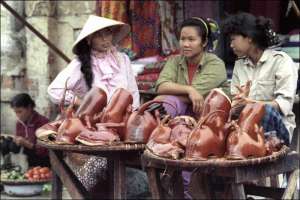 Женщины торгуют запеченной собачатиной на рынке в столице Вьетнама городе Ханое