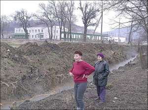Жительки села Мужієве Берегівського району Закарпаття Ганна Волошин (ліворуч) та Емма Аротюнова біля потічка з гарячою водою, що витікає з консервного заводу 