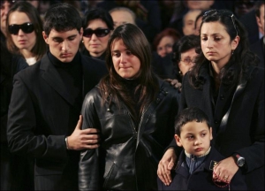 Филлиппо Рачити хоронили в Катанье 5 февраля. Жена Рачити Мариса Грассо (справа) стоит вместе с сыном Алессио. В центре - дочь полицейского Фабиана. Ее поддерживает друг семьи