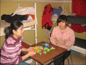 Китаянки Цен Тшюнь (ліворуч) та Лін Мейтін роблять із паперу іграшкових журавликів у мукачівському гуртожитку для нелегальних мігрантів на Закарпатті. Після затримання громадяни Китаю перебувають в Україні до півроку. Потім за рахунок уряду Китаю їх відпр