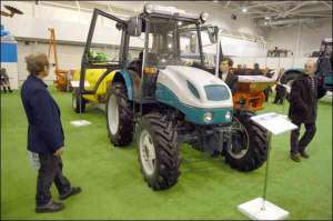 Представник Харківського тракторного заводу Олег Орламенко (в центрі) показує трактор серії 30 на аграрній виставці в Києві. Залежно від комплектації, така техніка коштує від 43 до 65 тисяч гривень