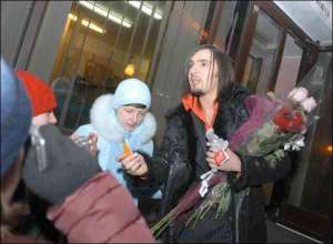 Фанатка Виталия Козловского просит у него автограф под столичным дворцом ”Украина”