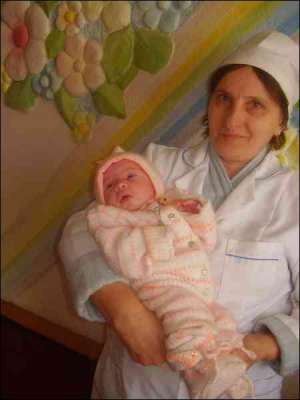 Дитяча медсестра пологового відділення козівської райлікарні Тернопільської області Марія Кадобна тримає на руках Уляну Мельник
