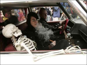Туристки катаются в катафалке со скелетом во время празднования Дня замерзшего покойника в американском городке Недерленд штата Колорадо