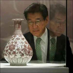 Директор ”Императорских торгов Кристи” Тео Тао в Гонконге разглядывает вазу после продажи