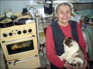 Софія Сапрун з котом Мацьком у своїй хаті в селі Плотича Козівського району на Тернопільщині. Баба Софія не була одруженою й не має дітей. Колись у неї був хлопець — партизан УПА   