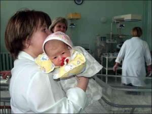 Медсестра Оксана Мацьків тримає на руках Анничку Стиранець у пологовому відділенні Львівської обласної лікарні