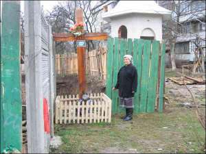 Юстина, мешканка івано-франківського будинку №2 на вулиці Сорохтея, показує хрест на місці запланованого новобуду. За хрестом видно викопаний котлован