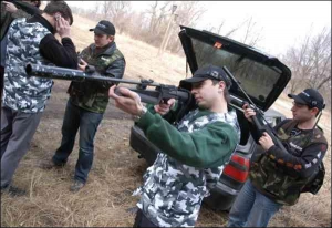 Василий Рудюк показывает участникам игры на Трухановом острове, как целиться из лазерной винтовки
