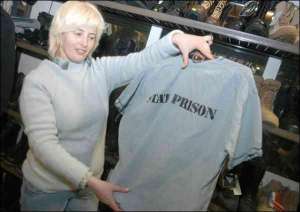Анжела, менеджер столичного магазина ”Полигон”, показывает рубашку за 60 гривен, стилизованную под одежду американского заключенного 