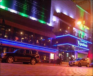 На вечерние сеансы в столичный кинотеатр ”Украина” зрители приезжают на дорогих машинах