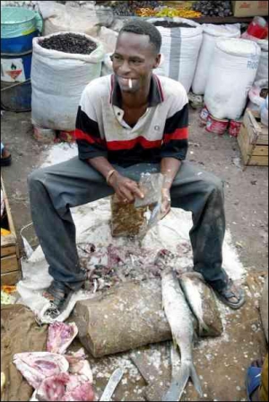 Работник супермаркета в столице Мавритании городе Нуакшот чистит свежую рыбу камнем. Рыба — основная еда в этой африканской стране