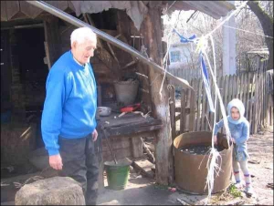 Сторічний Володимир Стрілецький із правнучатою племіннецею Іриною на подвір’ї своєї хати
