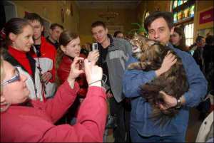 Посетители выставки фотографируют кота самой большой в мире породы мейн-кун. Взрослое животное весит 10–12 килограммов