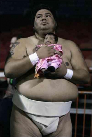 Американський спортсмен Марк Саґато тримає на руках свою двомісячну доньку Аврору на церемонії відкриття чемпіонату США із сумо у Лос-Анджелесі