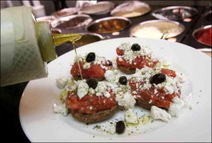 У грецькому ресторані на острові Крит салат ”Дакос” заправляють оливковою олією. На розмочений ячмінний сухарик кладуть помідори, козлячий сир ”фета” та маслини. У столичному грецькому ресторані ”Олвіо” готують схожий салат ”Теремосалато”. Він коштує 35 г