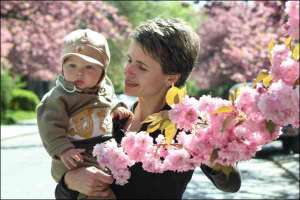 Жительница Ужгорода показывает сакуру своему сыну на Набережной Независимости. В городе расцвело около 1000 японских вишен