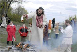 Верховний волхв організації ”Родове Вогнище Рідної Православної Віри” Володимир Куровський поливає ритуальне вогнище сурицею — напоєм із молока і меду