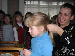 Вихователь Олександр Гоцик заплітає коси Оксані з молодшої групи Луцького дитсадка №8