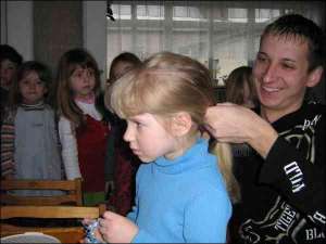 Вихователь Олександр Гоцик заплітає коси Оксані з молодшої групи Луцького дитсадка №8