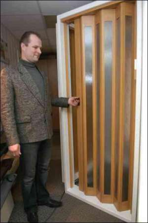 Директор магазину ”ХДМ-Україна” Євген Сопьянік показує найновішу модель дверей фірми ”Марлей”. Двері сріблястого кольору називаються ”Нова генерація” і коштують 1100 гривень