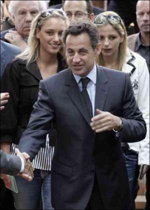 Ніколя Саркозі вітається з жителями на виході з виборчої дільниці у Нейлі-сюр-Сен, що на околиці Парижа. Його супроводжують падчерки Жудіт (ліворуч) та Жан-Марі Мартін (праворуч)