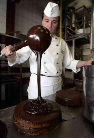 Кондитер Альфред Баксбейм поливає шоколадом Захер-торт на фабриці у Відні. Рецепт цього торта вигадали 175 років тому