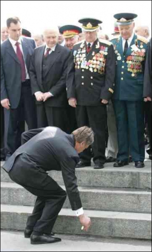 Віктор Ющенко піднімає медаль, яка відірвалася в одного з ветеранів. Потім президент причепив її йому на груди