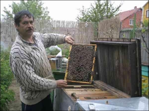 Владимир Надуличный возле собственной пасеки в Мукачево на Закарпатье. Показывает улей-финишер, в котором созревают пчелиные матки