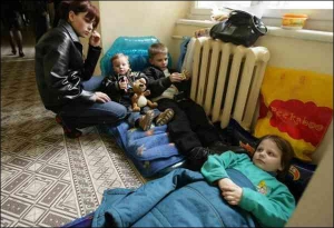 Світлана Струк (ліворуч) із 2-річним сином Андрієм, братом Дмитром (9 років) і сестрою Олександрою (8 років) сидять на надувних матрацах у коридорі Львівської міськради